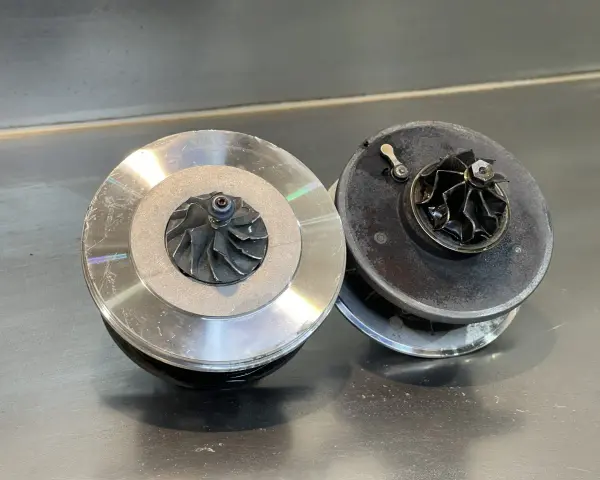 Due turbocompressori per motore, uno nuovo e uno usurato, pronti per un intervento.