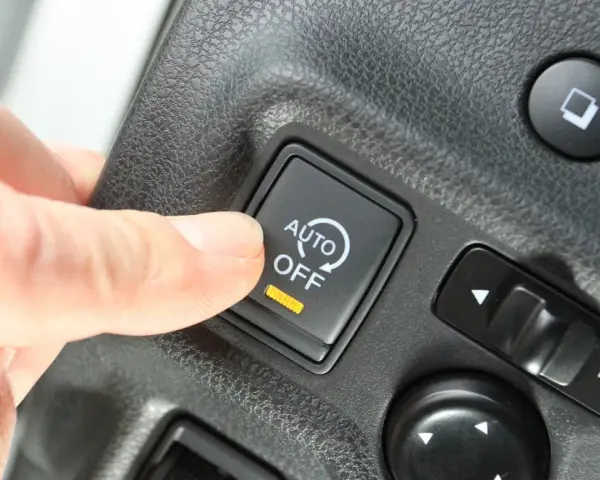Palec naciska przycisk "AUTO OFF", wyłączając system start-stop.