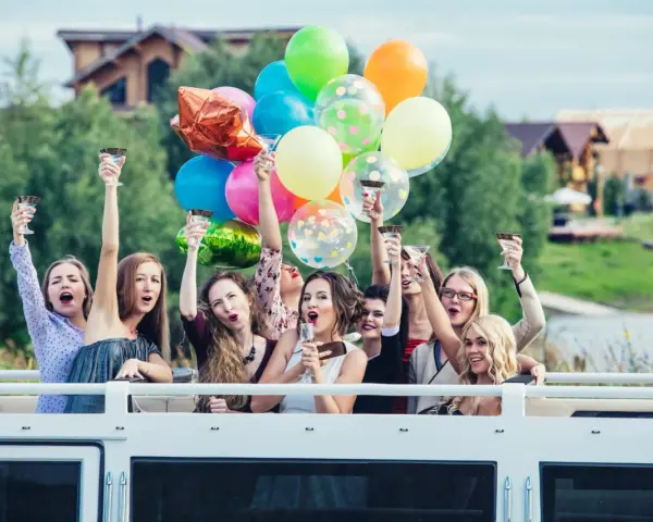 Radosne kobiety z kieliszkami i balonami świętują wieczór panieński. Mnóstwo kolorowych niespodzianek na wieczór panieński!