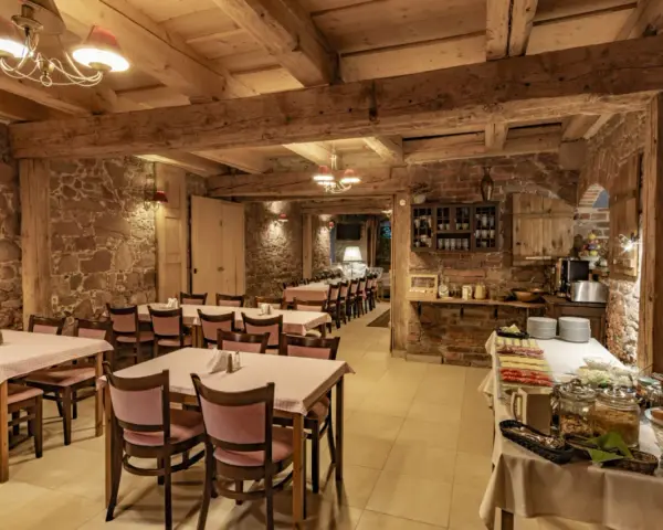 Przytulna restauracja w stylu rustykalnym, z kamiennymi ścianami i drewnianymi belkami. Idealne miejsce na posiłek w twierdzy Srebrna Góra.