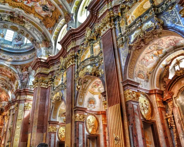 Bogata architektura baroku zachwyca złotymi zdobieniami, marmurowymi kolumnami i freskami na sklepieniach.