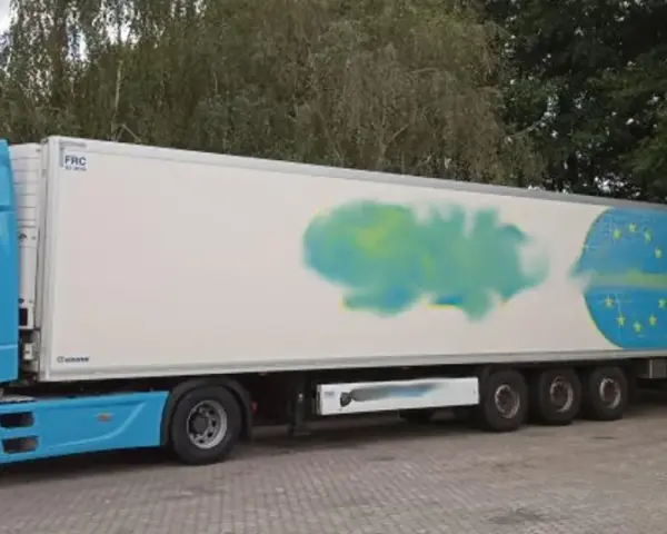 Niebieska ciężarówka z naczepą, na której widnieje symbol UE. Obok stoi biały bus inspekcji transportu drogowego. Certyfikat ATP potwierdza gotowość do przewozu.