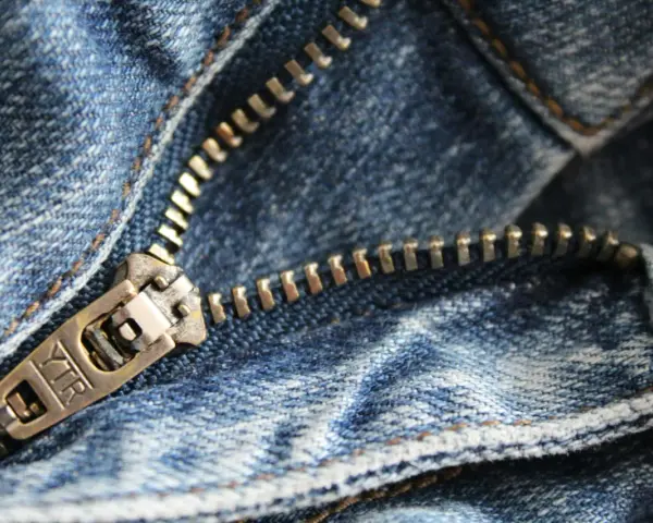 Primer plano de una cremallera de jeans. Aprende como arreglar una cremallera rota para que tus pantalones vuelvan a funcionar.