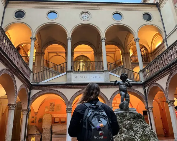 Cortile del Museo Civico, uno dei musei da visitare a Bologna, con una statua di putto e una persona con zaino.