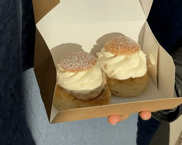 Två fluffiga semlor i en pappkartong, redo för fettisdagen 2026. Perfekt för en fika!