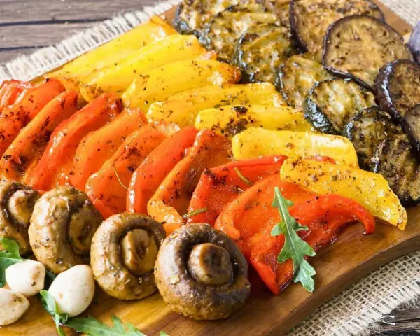 Eine bunte fingerfood antipasti platte mit gegrilltem Gemüse: Paprika, Zucchini, Auberginen und Champignons, appetitlich gewürzt.