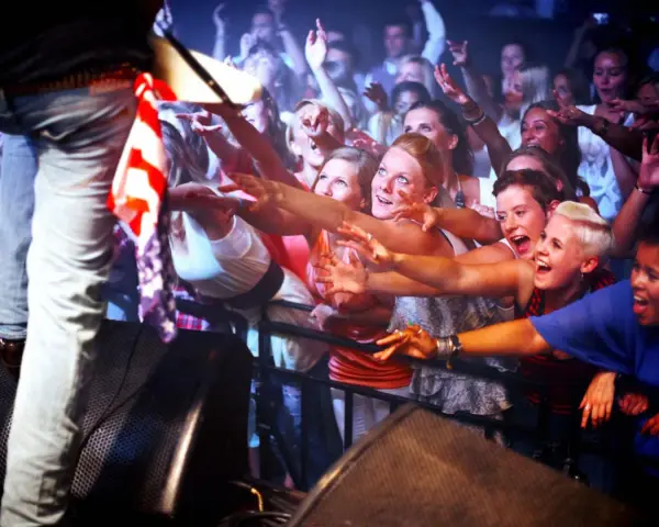 Begeisterte Fans, die nach ihrem Idol greifen – so sehen sie aus, die Groupies, die die Energie eines Konzerts spüren.