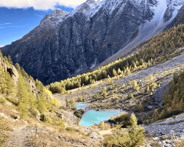 Magnifique lac turquoise au cœur d'une vallée alpine aux couleurs d'automne, parfait pour un tour des Écrins 10 jours.