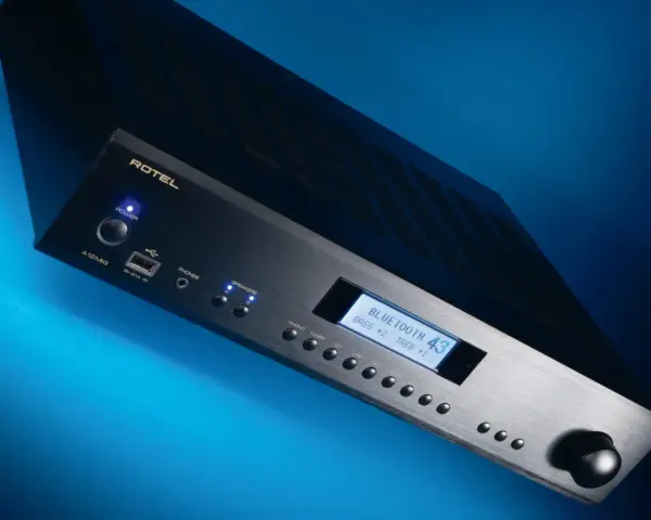 Czarny wzmacniacz Rotel A12 MKII z niebieskim podświetleniem, wyświetlaczem Bluetooth i pokrętłem głośności.