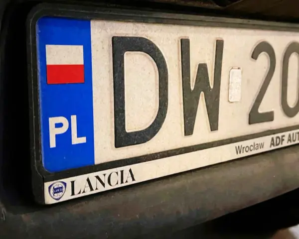 Tablica rejestracyjna z napisem "DW 209" i flagą Polski. Zsd rejestracja Lancia z Wrocławia.