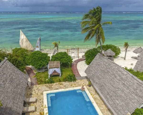 Zanzibar w lutym: słoneczna pogoda, turkusowe morze, palmy i urocze domki z krytymi dachami. Idealne miejsce na relaks.