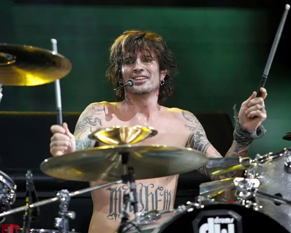 Tommy Lee, batteur du groupe, frappe sur sa batterie, torse nu, tatoué, en plein concert.