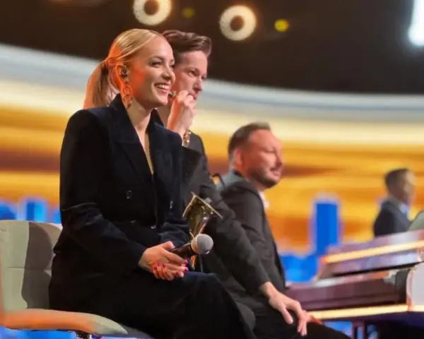 Uśmiechnięta wokalistka, która śpiewa w "Jaka to melodia", siedzi obok pianistów na scenie.