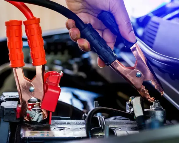 Starthilfe: Rote Klemmen an der Batterie, dann schwarze. Welcher Pol zuerst? Die rote Klemme wird zuerst am Pluspol befestigt, dann die schwarze am Minuspol.