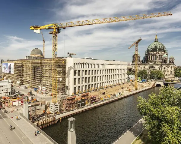 Baustelle am Berliner Dom, Kräne ragen in den Himmel. Ein neues Gebäude entsteht, während der Dom in seiner Pracht erstrahlt. Ein Blick auf das heutige Berlin, das sich ständig neu erfindet.