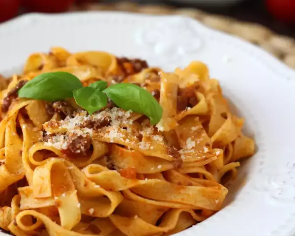 Breite Bandnudeln mit herzhaftem Ragout Bolognese, garniert mit frischem Basilikum und Parmesan. Ein Klassiker, der immer schmeckt.