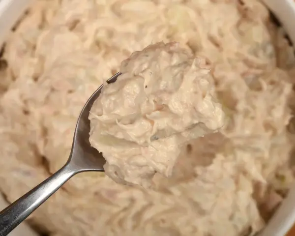 Łyżka pełna kremowej pasty z tuńczyka, gotowa do podania. Idealna na kanapki lub jako dodatek.