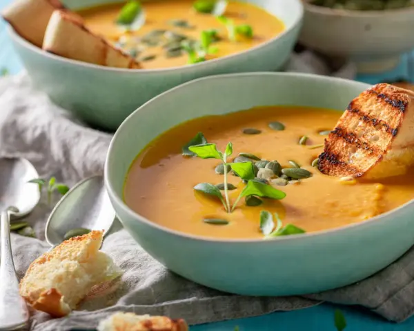 Cremige Kürbissuppe mit geröstetem Brot und Kürbiskernen. Perfekt für leichte, wohltuende schonkost rezepte.