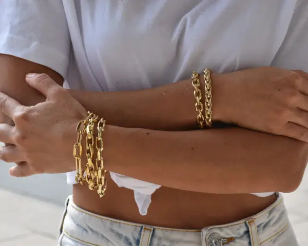 Bracciali in oro 18 carati, più brillanti e preziosi rispetto all'oro 9 carati, adornano le braccia di una donna.