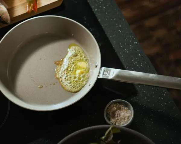 Butter schmilzt in einer beschichteten Pfanne, bereit für Fisch. Die Pfanne ist leicht zu reinigen.
