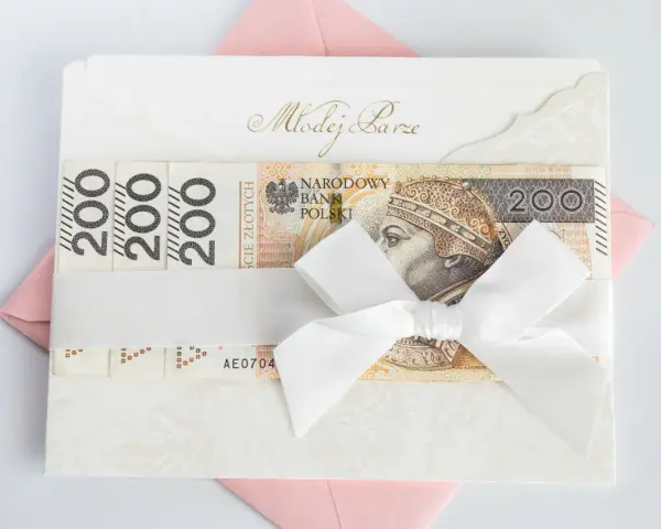 Elegancka koperta z napisem "Młodej Parze", ozdobiona banknotami 200 zł i białą wstążką. Idealny sposób, jak udokumentować pieniądze z wesela.