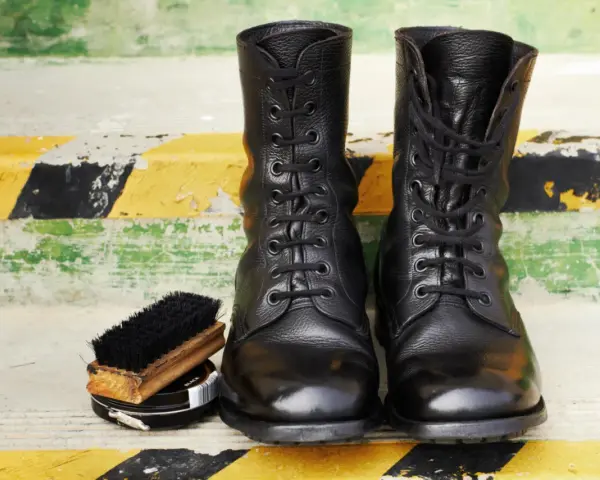 Botas militares negras, cepillo y betún. Aprende como limpiar botas militares para que luzcan impecables.