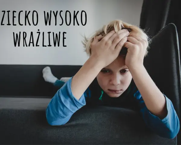 Chłopiec z rękami na głowie, wyrażający smutek. Napis "DZIECKO WYSOKO WRAŻLIWE" sugeruje, że może to być wyraz jego emocji.