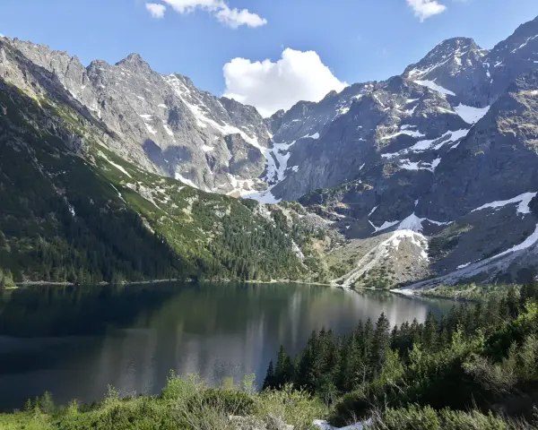 Majestatyczne góry otaczają spokojne Morskie Oko, odbijając w swojej tafli skaliste szczyty i zielone lasy.