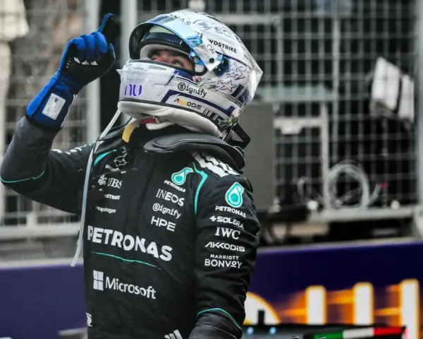 Piloto de F1 con casco y guantes azules levanta el dedo índice, celebrando una victoria en la carrera F1 Mónaco.