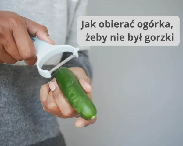 Dłonie obierają ogórka obieraczką. Dowiedz się, od której strony obierać ogórka, by nie był gorzki.