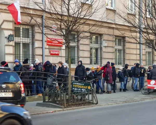 Kolejka do odbioru paszportu w Krakowie. Ludzie stoją przed budynkiem urzędu.