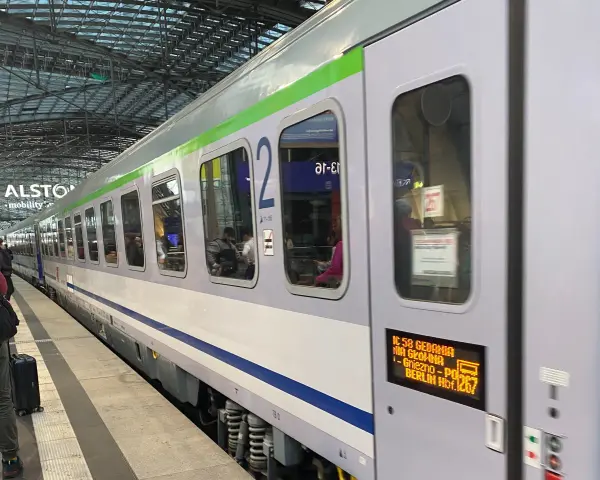 Pociąg IC 58 Gedania z Gniezna do Berlina stoi na peronie. Widać pasażerów w środku.