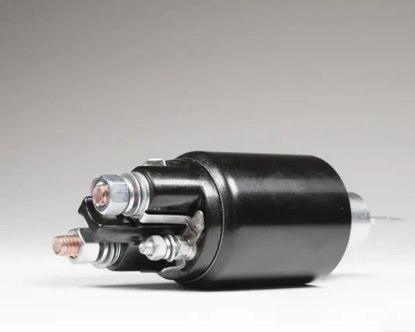 A black starter solenoid with copper and silver bolts, ready to power up an engine.