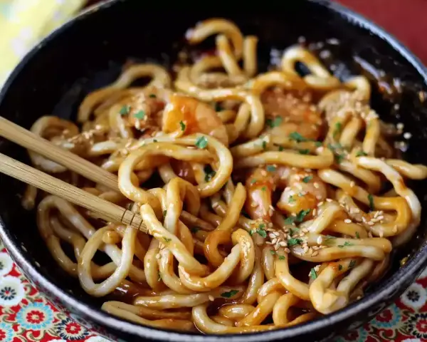 Makaron konjac z krewetkami w sosie, posypany sezamem i natką pietruszki. Prosty sposób, jak gotować makaron konjac.