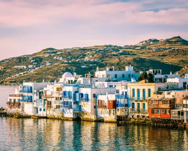 Charming waterfront houses with blue shutters, a classic view of places in Greece to visit.