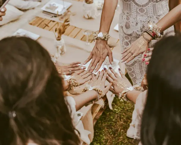 Dłonie ozdobione tatuażami "Team Bride" i bransoletkami z kwiatów. Wspaniałe panieńskie pomysły na celebrację!