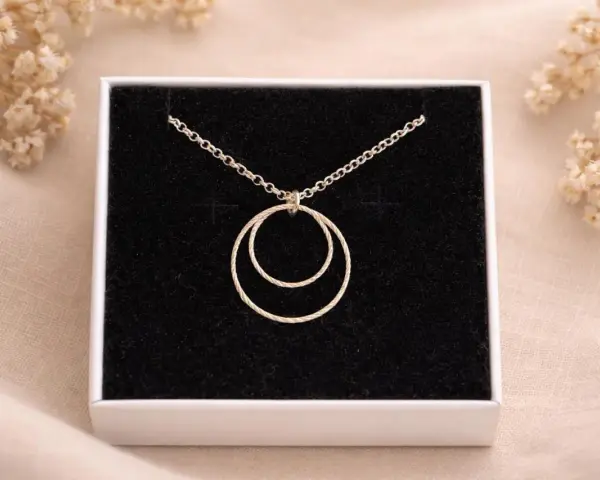 Collana con due anelli intrecciati, simbolo di legame eterno e unione.