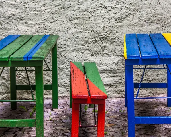 Muebles coloridos, como mesas y bancos, hechos con **objetos reciclados fáciles de hacer**.