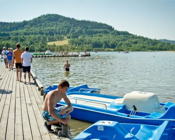 Letni dzień nad jeziorem, popularne wśród turystów śląskie atrakcje turystyczne. Ludzie odpoczywają na pomoście i w wodzie.