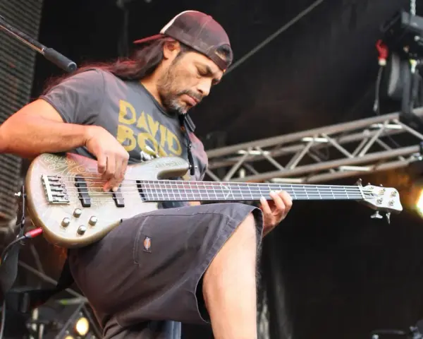 Robert Trujillo z zespołu gra na basie, skupiony na występie.