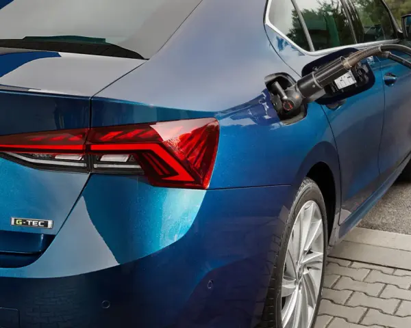 Rifornimento di un'auto blu con motore a metano. La pompa è inserita nel serbatoio.