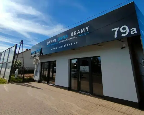 Nowoczesny salon z oknami i drzwiami, z szyldem "DRZWI OKNA BRAMY" i numerem 79a.