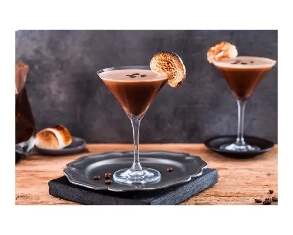 Espresso Martini przepis: dwa eleganckie kieliszki z kawowym drinkiem, ozdobione palonymi piankami i ziarnami kawy. Idealny na wieczór.