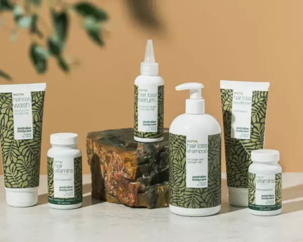 En samling hårvårdsprodukter med biotin, inklusive schampo, balsam, serum och kosttillskott. Biotin mat för starkare hår.