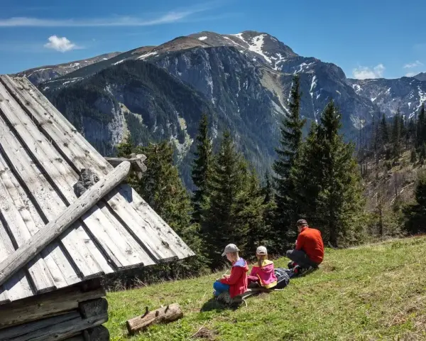 Rodzina odpoczywa przy szałasie, podziwiając Tatry. Idealne tatry atrakcje dla leniwych, gdzie można usiąść i cieszyć się widokiem.