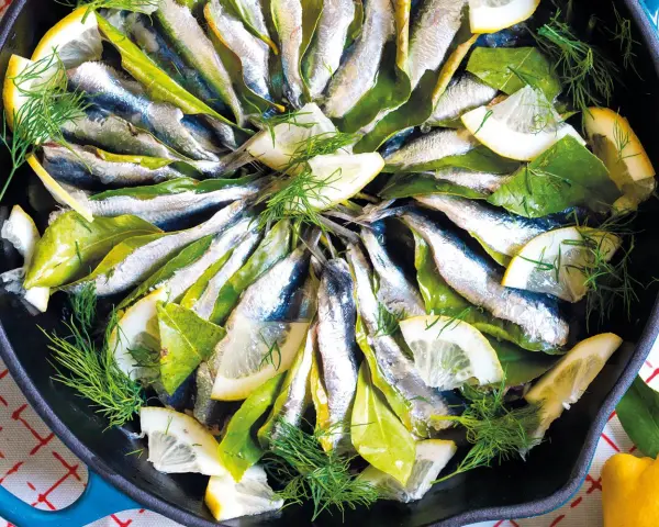 Sardine in padella con limone, alloro e finocchietto, pronte per essere gustate.