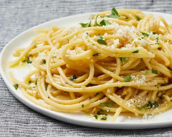 Pyszny makaron aglio e olio, idealny pomysł, z czym zrobić makaron na szybko. Posypany parmezanem i natką pietruszki.