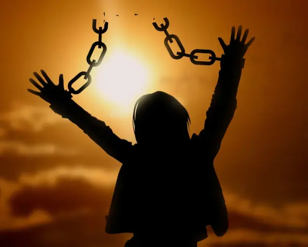 Silhouette einer Person, die sich von Ketten befreit, symbolisiert die Vergebung, wie sie in der Bibel gelehrt wird.