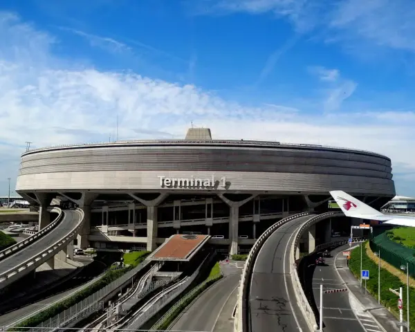 Terminal 1 na lotnisku w Paryżu, najbliżej centrum, z charakterystyczną architekturą i drogami dojazdowymi.