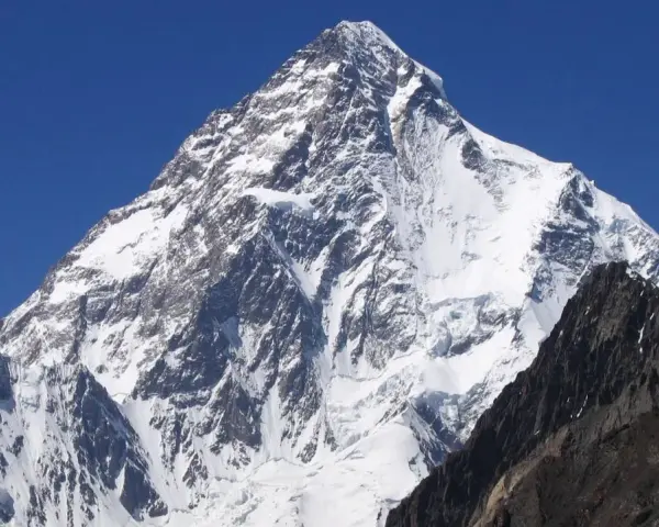 Lodowy gigant K2, najwyższy szczyt Karakorum, wznosi się dumnie na tle błękitnego nieba.